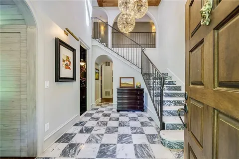Grand marble foyer with checkered floors and chandelier